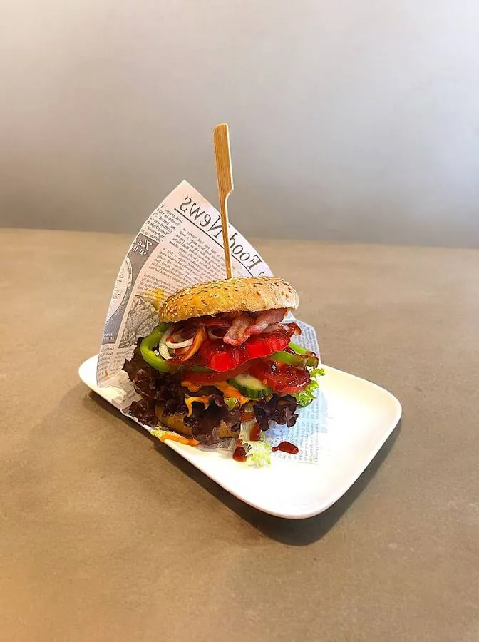 Burger mit Bacon und frischem Gemüse, serviert im Sprechzimmer